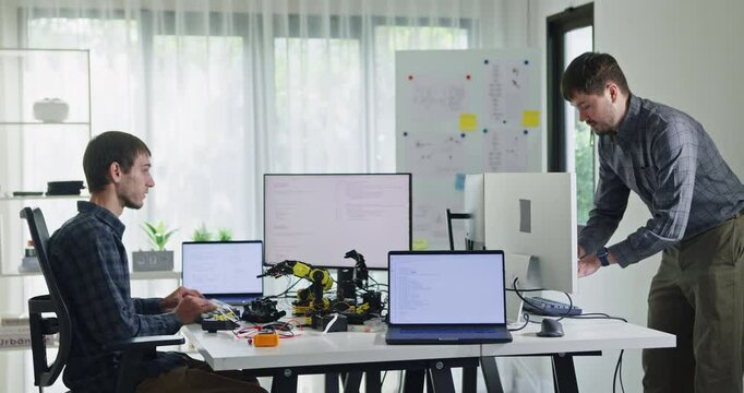 Team of male developers work code control robotics system and software automation project write prompt AI data bot at office. Artificial intelligence, collaboration, robotic, debugging, machine learn.