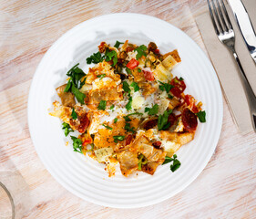 Plate of tasty and nutritious breakfast - scrambled eggs with bacon and sausage