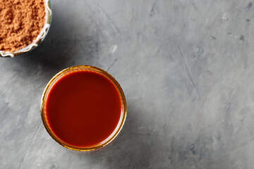 Cocoa Drink in Ridged Glass and Bowl of Cocoa Powder on Gray Concrete Background, Copy Space