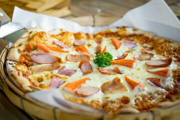 A delicious pizza topped with various meats and vegetables, garnished with parsley, served in a rustic basket.