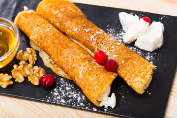 Traditional Bulgarian Palachinka crepes stuffed with brinsen cheese and walnut served with honey..
