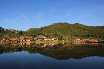 Fototapeta premium Beautiful scenery water reflection of the Chinese village at the Ruk Thai Lake in Mae Hong Son Province, Thailand