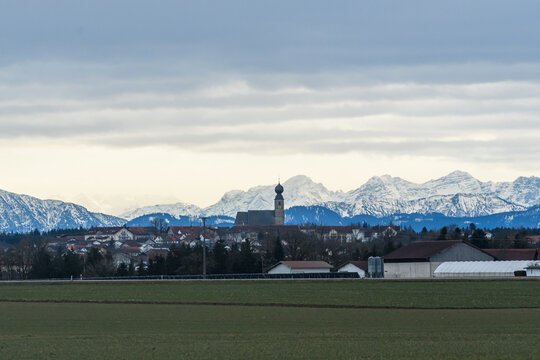 Ort vor verschneiten Alpen in Oberbayern im Winter