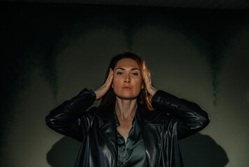 Serene young caucasian female in leather jacket against mysterious backdrop
