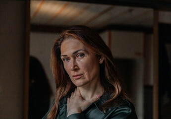 Thoughtful mature caucasian female indoors in casual attire