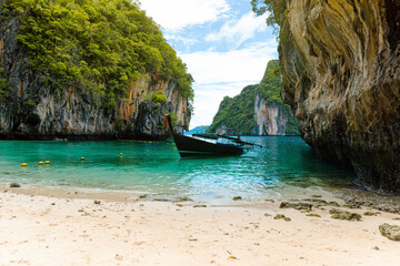 Lading Beach in Krabi, Thailand, surrounded by clear turquoise water, dramatic limestone cliffs, and lush greenery. A serene tropical escape perfect for nature lovers and peaceful retreats.
