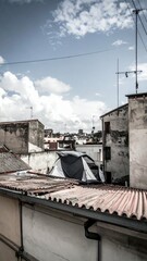 Fototapeta premium Makeshift Shelter on Rooftop Under Blue Sky with White Clouds