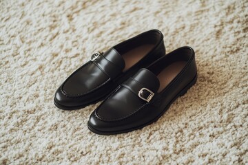 Black leather loafers on beige rug.