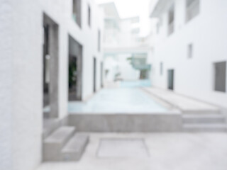 Abstract blurred scene of modern construction building with blue water in the swimming pool, blurred exterior outdoor with geometric design hotel or residential background, minimal style.