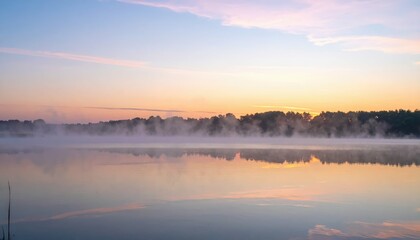 Obraz premium Calm Sunrise Over Misty Lake with Soft Pastel Colors and Reflection