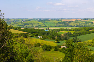 Obraz premium Agricultural landscape of hills, hedges, and forests in the valley of the Lèze from the village of Carla-Bayle