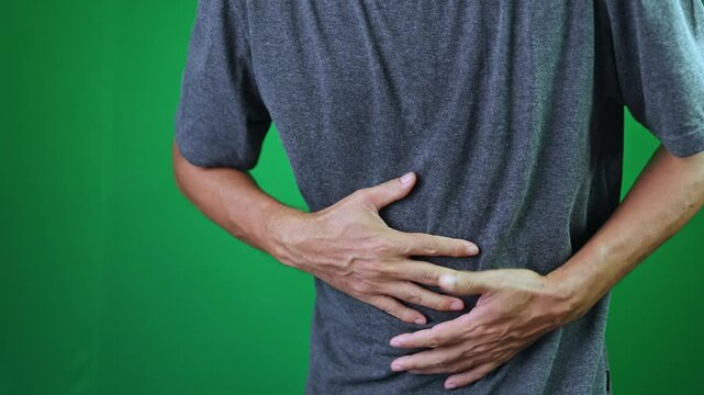 man feels abdominal pain, stomach ache, man having pains in stomach on chroma key green screen background, abdomen ache of adult, bloating concept, suffering from belly ache, male has sick heartburn