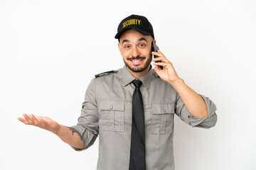 Young security  caucasian man isolated on white background keeping a conversation with the mobile phone with someone