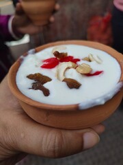 This Indian beverage is called Lassi served in mud cup with dry fruits.
