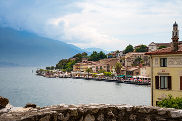 Panoramic view from an elevated position of the waterfront promenade and the old town of Limone sul Garda on Lake Garda in Italy. Travel photography