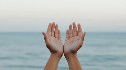 Artistic close-up of hands in mudra with sea in the background
