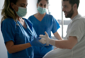 Doctor changing bandage of patient in hospital room