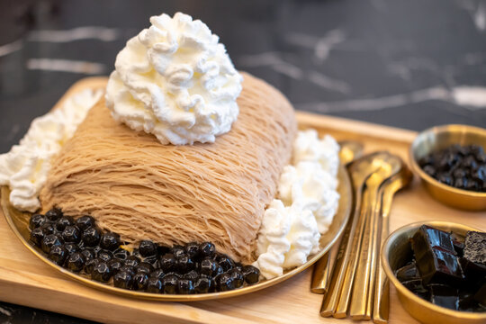 Tea bingsu served with grass jelly, boba and whipped cream