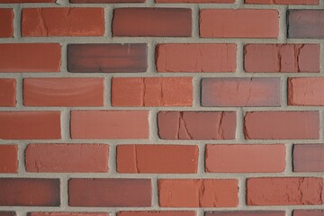 Obraz premium Textured red brick wall showcasing a variety of shades and patterns, adding character and warmth.