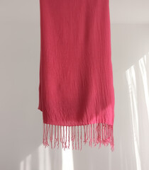 Pink scarf on light background with copy space. Concept of fashion, style, textiles, apparel, craftsmanship 