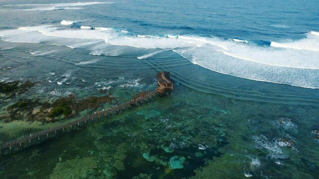 drone view of a Boardwalk and Breaking Waves from above at Cloud 9 Surf Spot in Siargao, Philippines