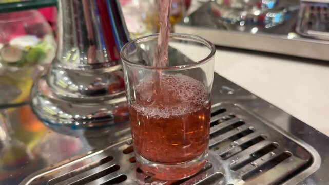 pouring red drink into grape juice at the buffet