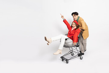 Happy young Asian couple tourist with shopping cart isolated on white background, Shopping in winter season concept
