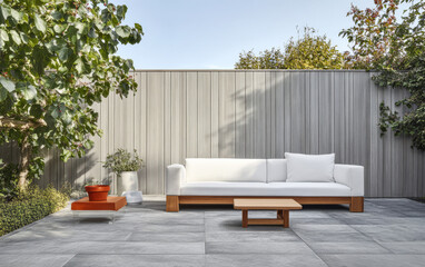 Modern outdoor lounge area with white sofa and wooden coffee table in serene garden setting