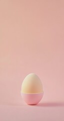 Pale yellow egg in small pink bowl on pastel pink background