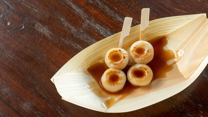 Two Dango on a wooden table.