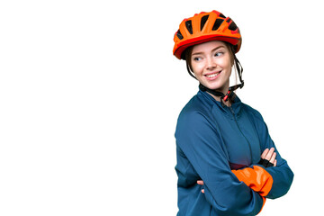 Young cyclist woman over isolated chroma key background with arms crossed and happy