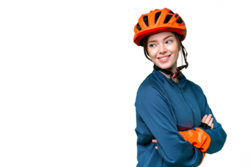 Young cyclist woman over isolated chroma key background with arms crossed and happy