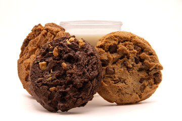 3 cookies posés devant un verre de lait sur fond blanc, cookies au chocolat et aux pépites de chocolat