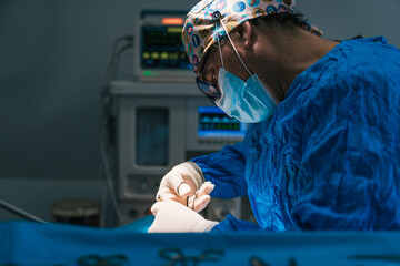 Veterinarian surgeon concentrating while performing a surgical operation in a veterinary hospital operating room