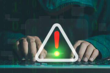 A hacker attacks and hacks data on computers. A businessman is using a computer with a triangle...