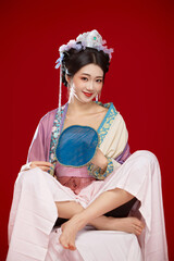 Beautiful woman wearing Chinese Ming Dynasty Hanfu with hairpin and flower ornaments on red...