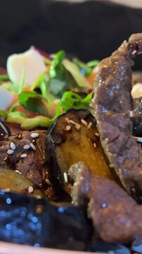 Aubergine salad. Top view of a healthy eggplant salad garnished with parsley. Eggplant Salad, Grilled vegetables salad, Salad grilled meat. Steak salad fork