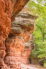 The Path road along red rock formations reserve Altschlossfelsen in the Saarland region of Germany the stones have a bright red and orange color and abstract form