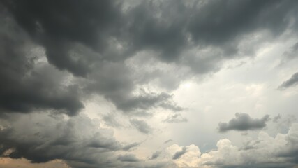 Obraz premium Dramatic dark grey storm clouds fill the overcast sky creating a moody atmospheric background image perfect for design projects.
