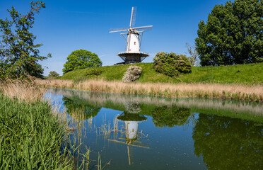 Reflections of a traditional windmill in the colorful countryside surrounding Veere, Zeeland, Netherlands