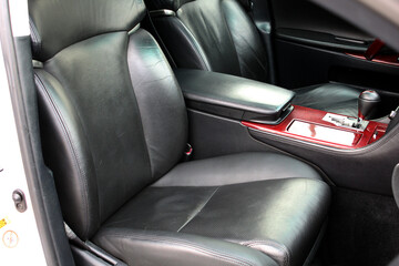 Premium car interior with light black high-tech comfortable seats and wooden trim. Lux car armrest with Automatic transmission lever shift. Automatic gearbox lever.