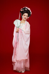 Beautiful woman wearing ancient Chinese Tang Dynasty costume against red background