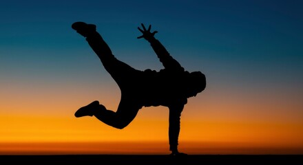 Silhouette person performing dynamic dance move against sunset