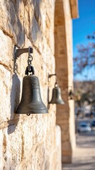 Antique bell hanging on a stone wall architectural element