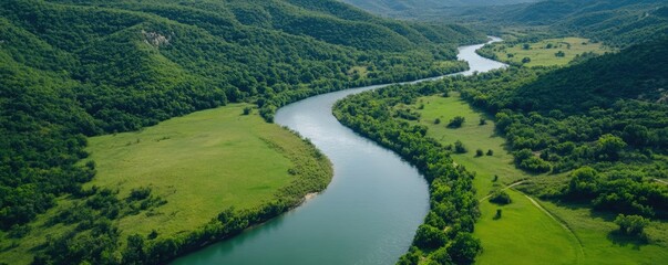 Fototapeta premium Scenic river landscape flowing through green hills and forests aerial view