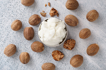 Jar of shea butter with nuts on grunge background