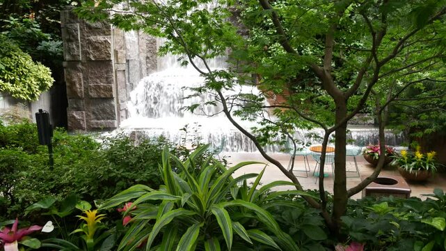 New York City life, urban public park, Greenacre park waterfall. American Manhattan Midtown, USA. Recreation zone summer tropical flowers on flowerbed, trees greenery. Green oasis on 51 street in NYC.
