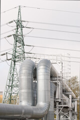 pipeline and power line against gray sky