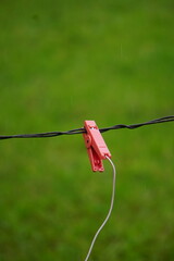 Podpięcie napięcia do ogrodzenia. Prąd płynie w ogrodzeniu na pastwisku. © Adam