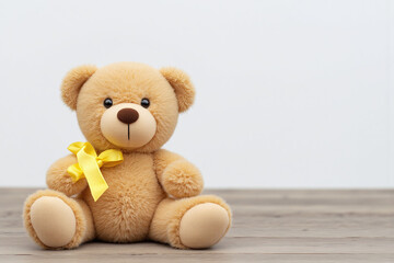 teddy bear with a yellow ribbon sitting on the floor